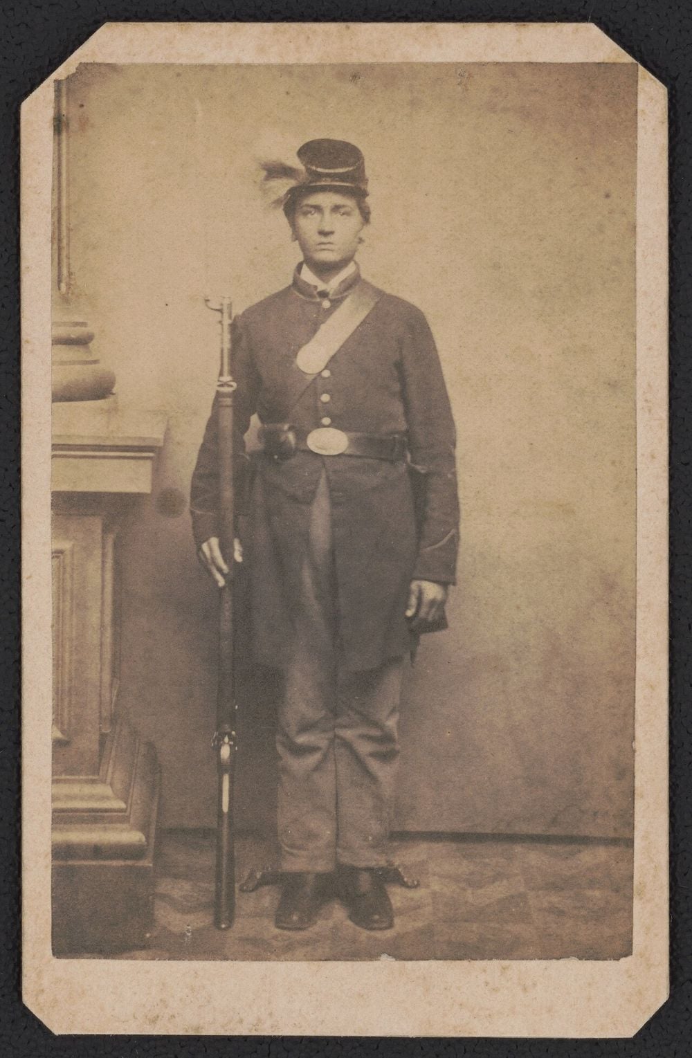 Civil War portrait of Private Franklin W. Lehman of the Bucktails regiment in uniform, holding a musket, with a deer tail on his cap